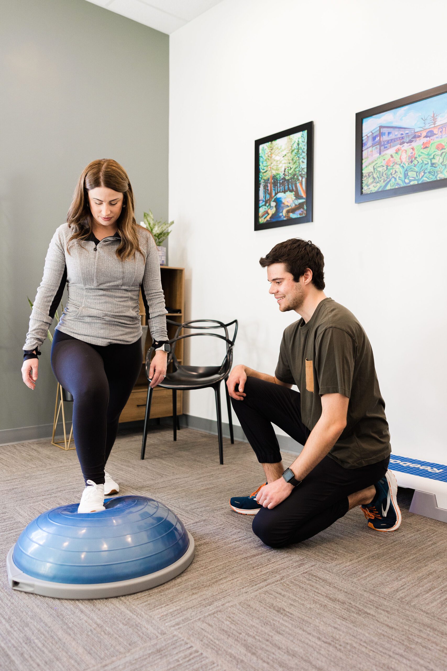 Physiotherapist William Howatt overseeing a client perform a split squat on a bosu ball